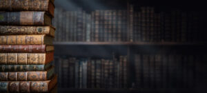 Old books on wooden shelf and ray of light. Bookshelf history theme grunge background. Concept on the theme of history, nostalgia, old age. Retro style.